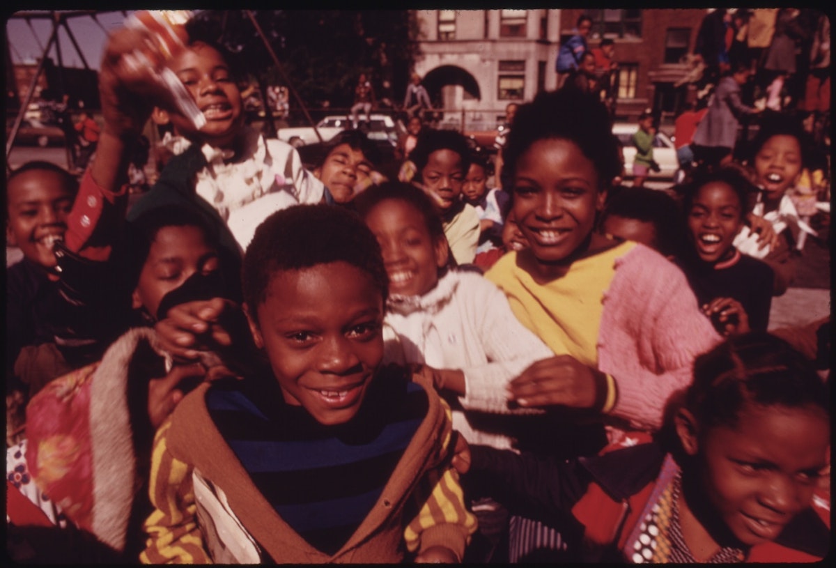 Photograph by John H. White of children crowding round the camera