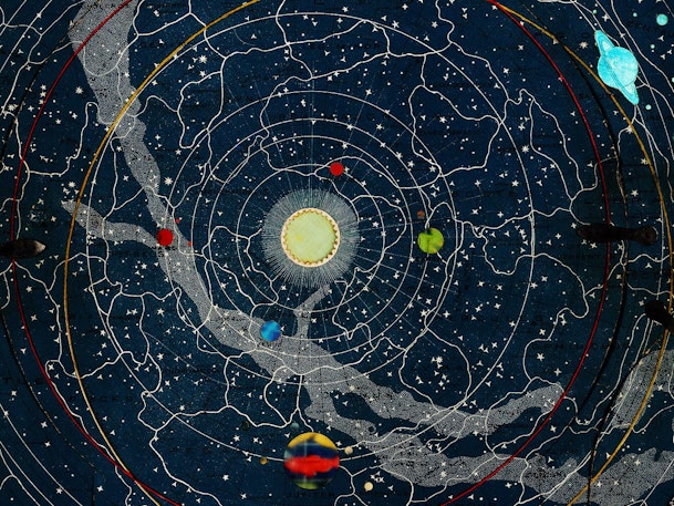 Astronomical illustration showing a detailed star map with zodiac constellations and the solar system's orbital paths, highlighted by colorful planets against a dark blue starry background