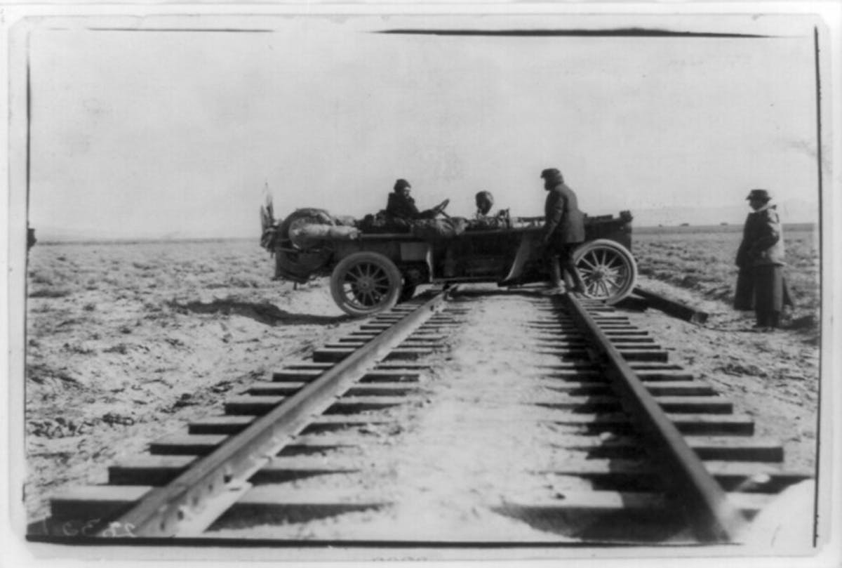 car straddling railroad