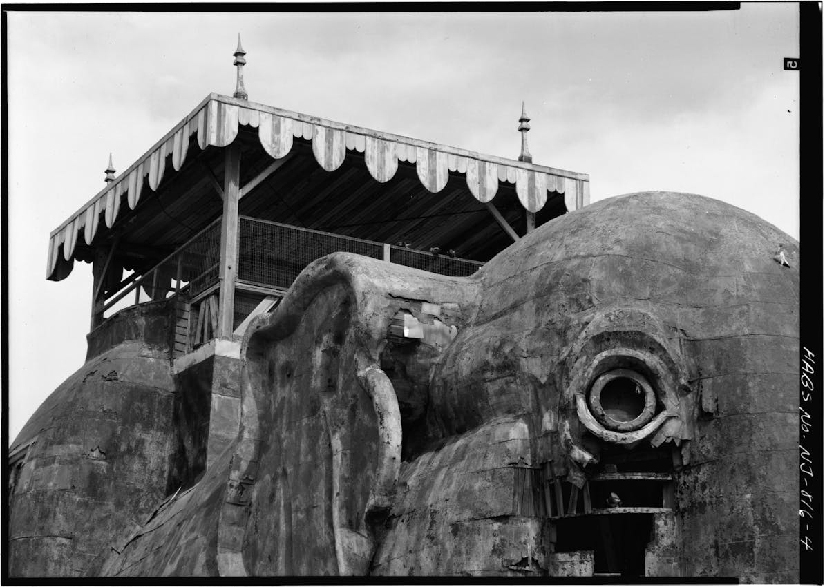 Elephant building with its eye dominating the foreground with a canopied terrace on its back