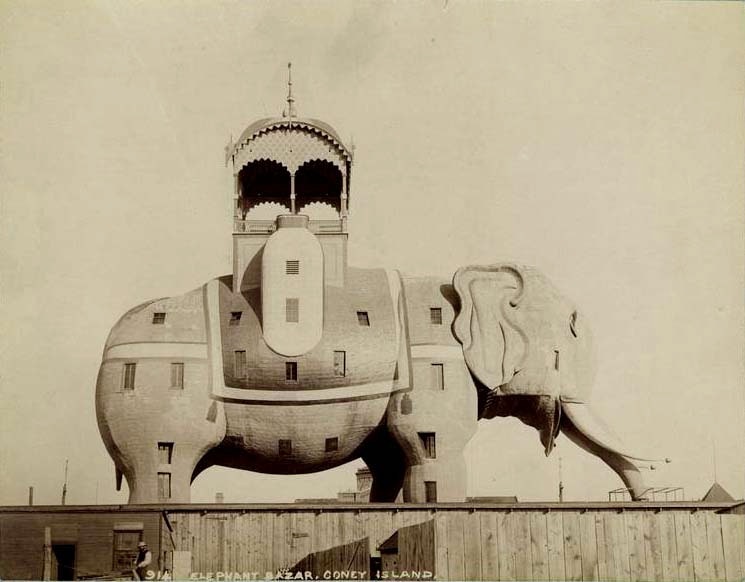 The elephant stands several stories tall with a covered pavilion on its back