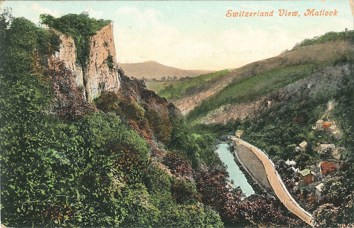 A landscape with rock promontory overlooking a river valley with road and buildings below