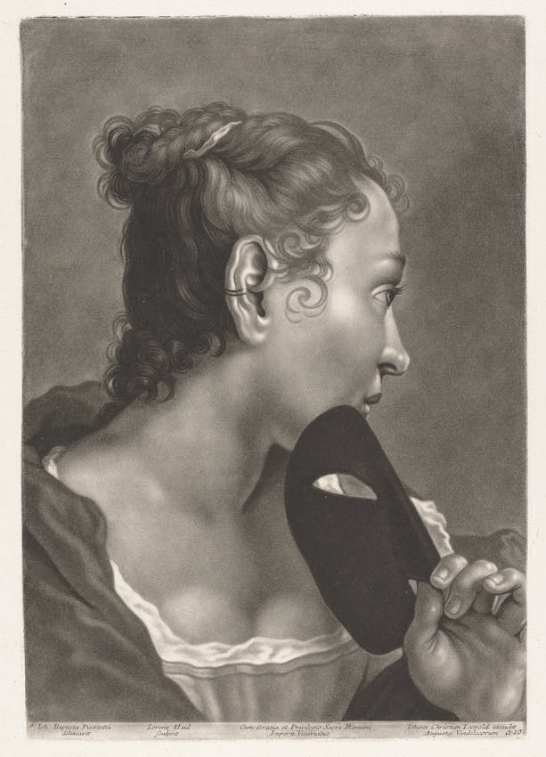 A profile portrait of a woman with curly hair tied up in a three-quarter view holding a mask against her chin.