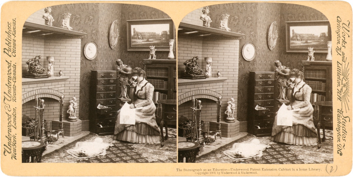 stereograph of a woman looking at a stereograph