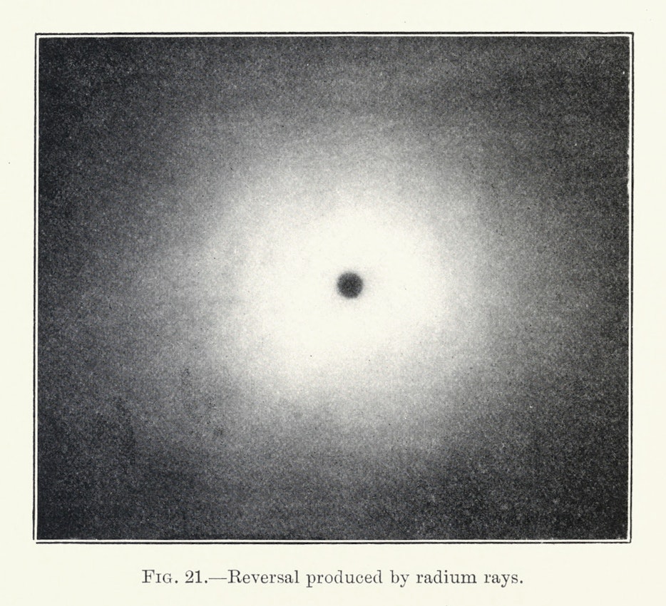 An image of a small pinpoint of black surrounded by white demonstrating “photographic reversal” through prolonged exposure to radium