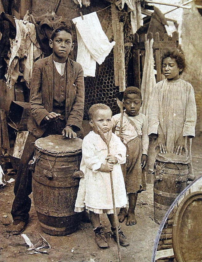 Four children in an outdoor space with drums
