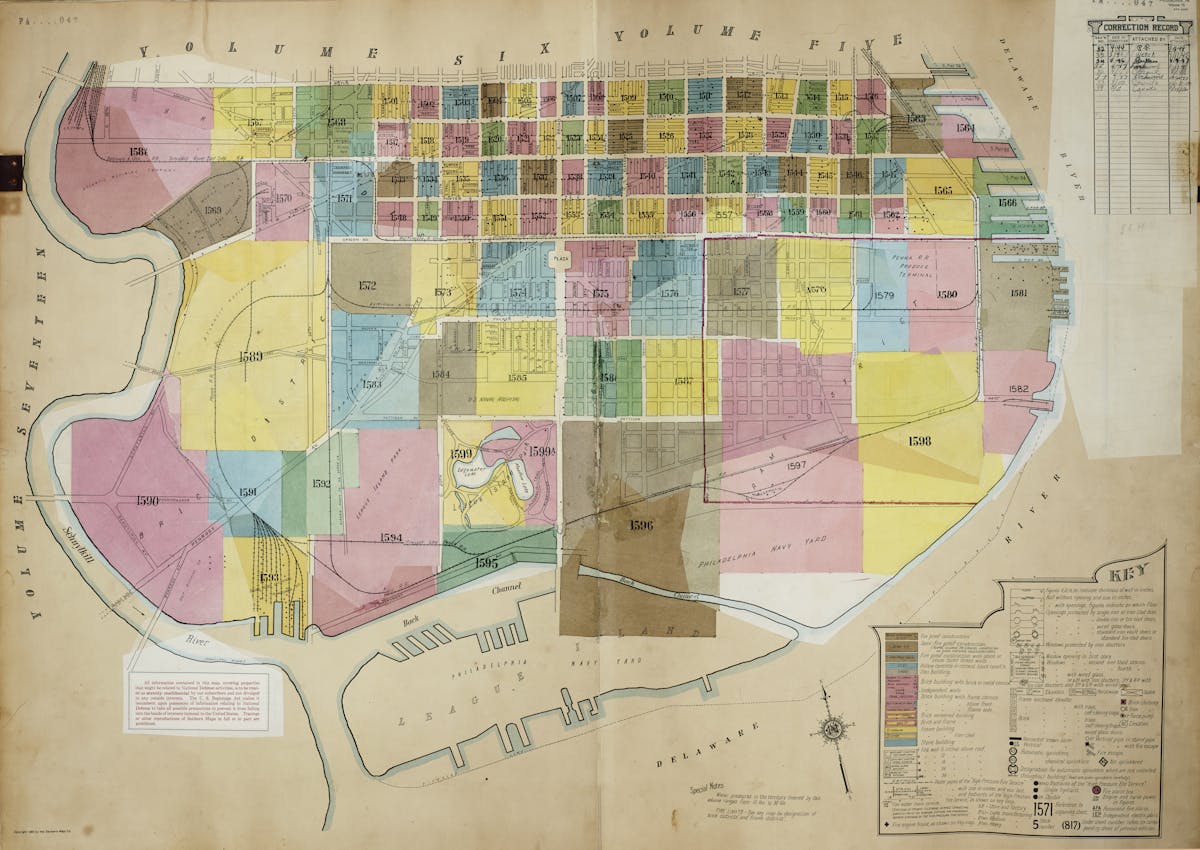 This map illustrates a city area with multiple color-coded zones, each labeled with specific numbers. It includes a key explaining the symbols and colors used, and shows landmarks such as rivers, a navy yard, and various streets and blocks.